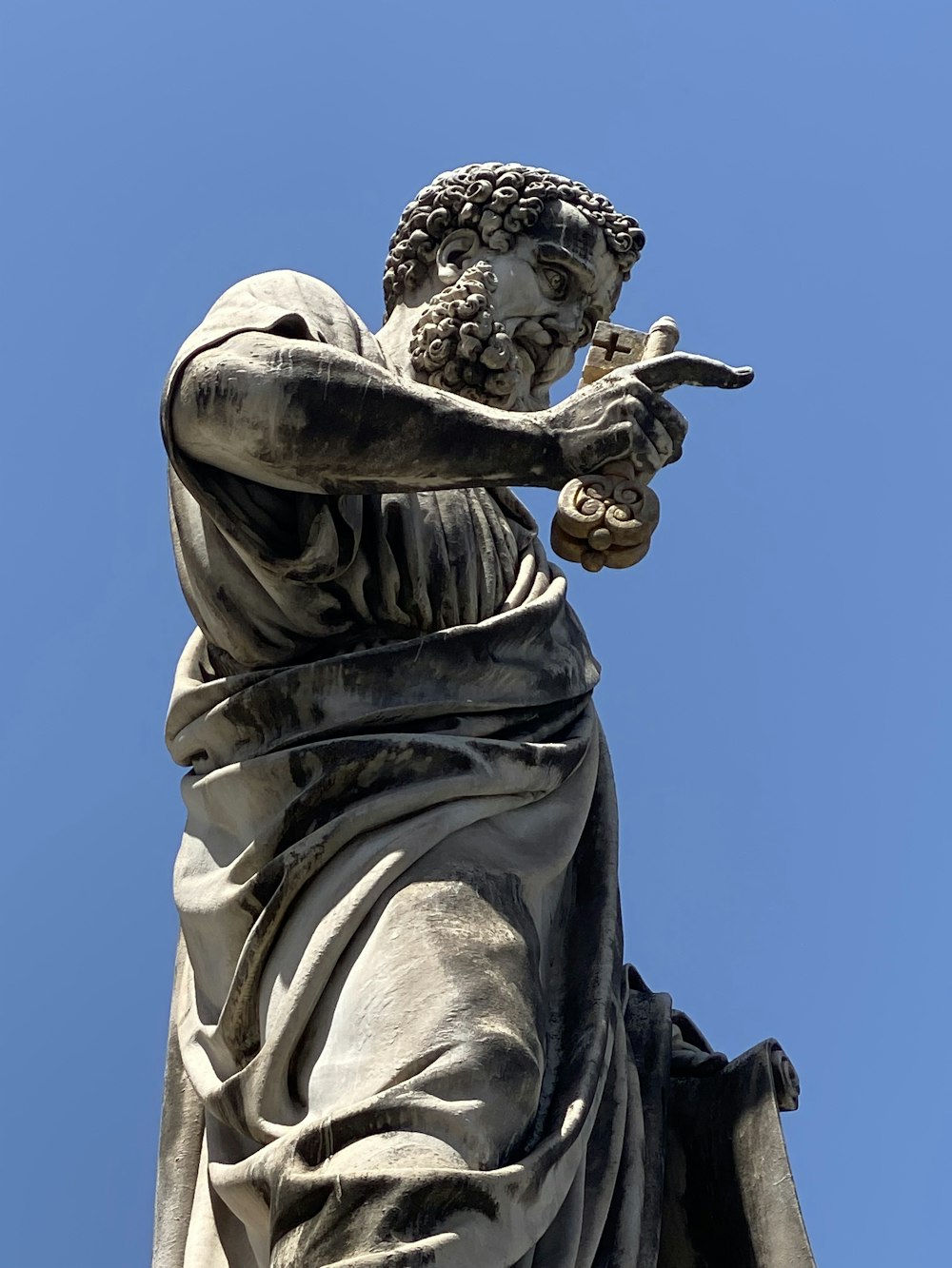 a statue of a person holding a cross