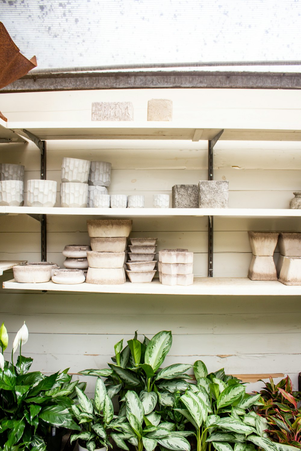 a white shelf with white containers on it
