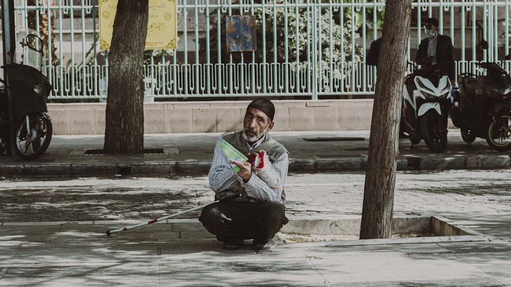 une personne assise sur le trottoir