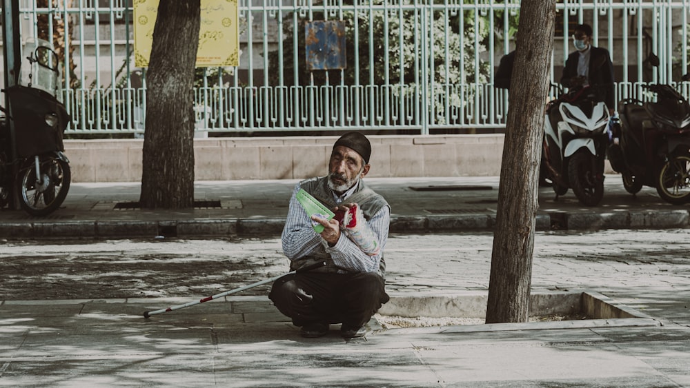 a person sitting on the sidewalk