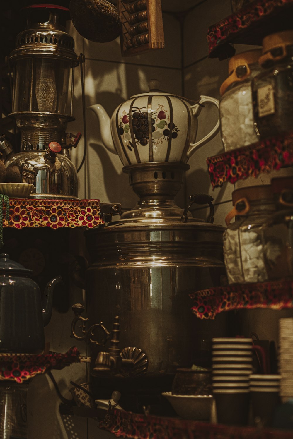 a large metal kettle sits on a shelf