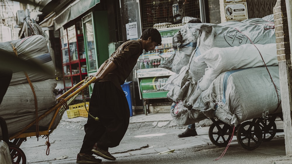 a man pushing a cart full of bags