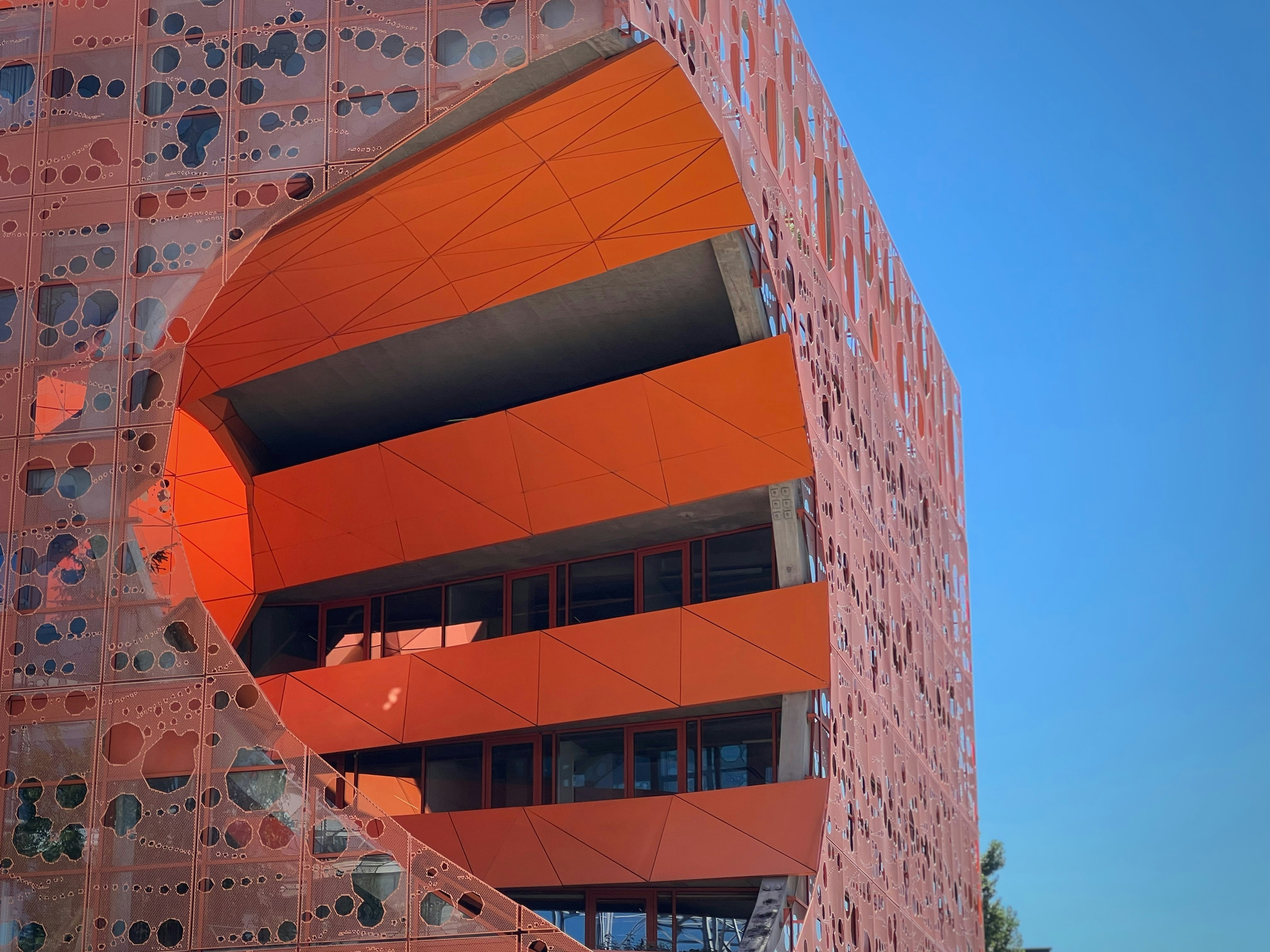 A building with a red and yellow exterior photo – Free Orange cube ...