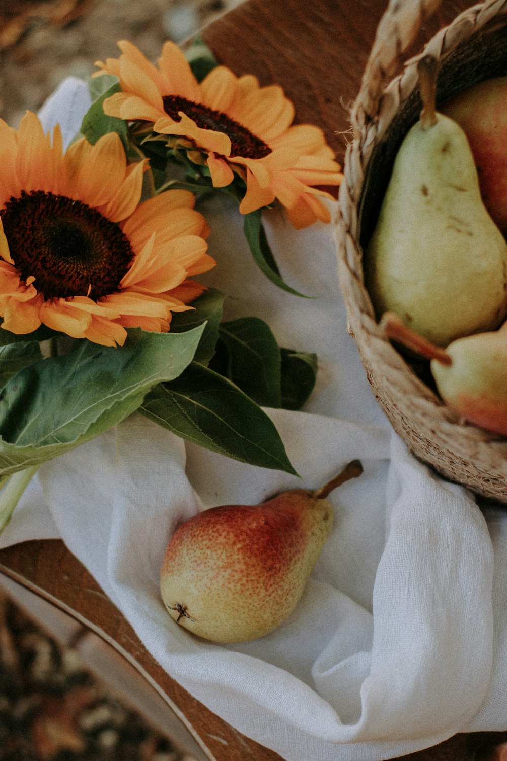 a white plate with a fruit on it next to a basket of flowers