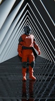 A person dressed in a red spacesuit with black accents and a helmet stands in the center of a futuristic, geometrically patterned tunnel. The tunnel walls create a repeating pattern of triangles, leading to a vanishing point, and the floor reflects part of the scene.