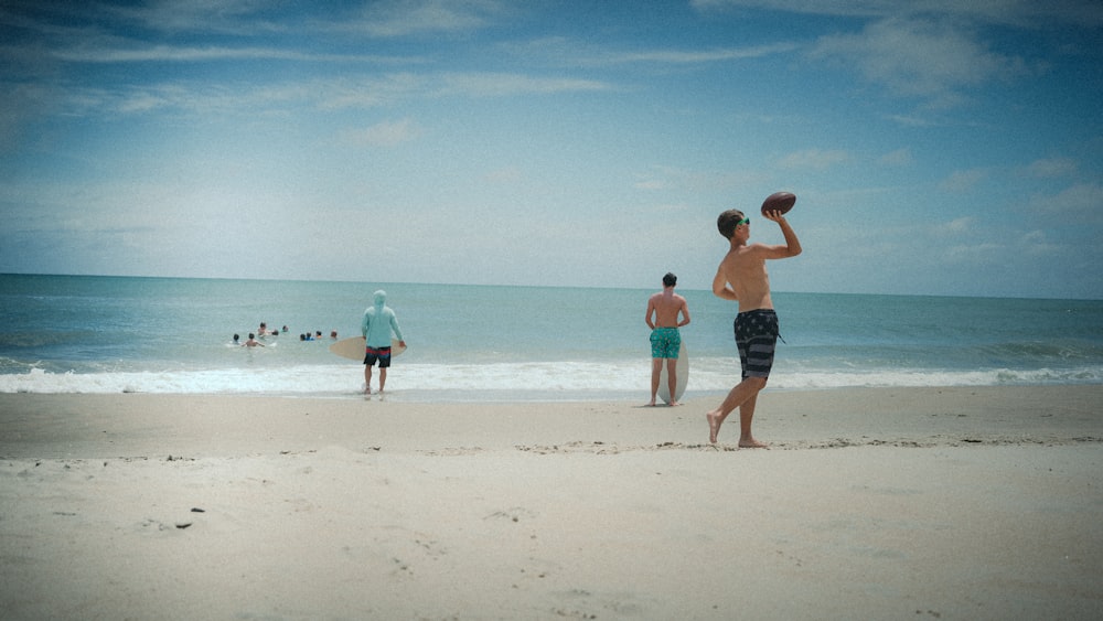 a group of people playing frisbee on a beach