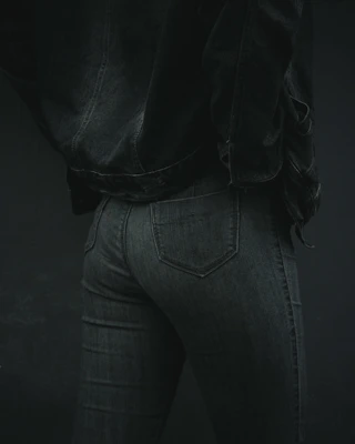 Tailored dark denim pants displayed on a mannequin, highlighting the fabric texture.