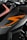 A close-up view of a motorcycle part featuring sleek black and orange design elements. The bodywork showcases the word 'SUPERDUKE' in stylized white text. The logo 'KTM' is also visible, indicating the motorcycle's brand. The image focuses on the angular lines and the modern, aggressive styling of the vehicle.