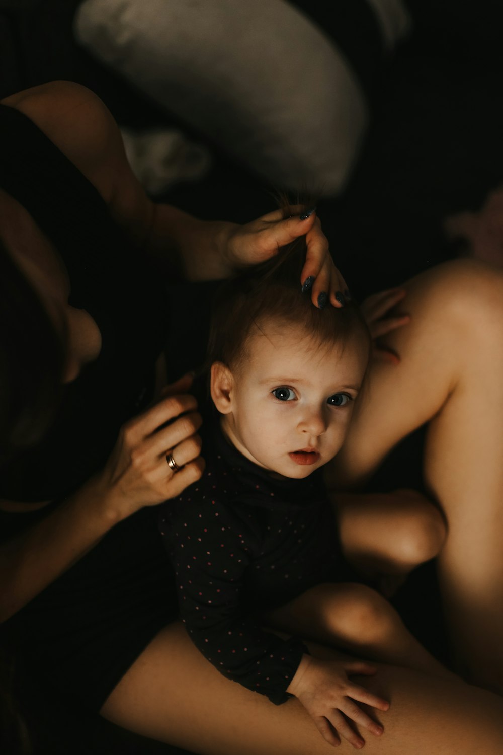 a baby lying on a woman's lap