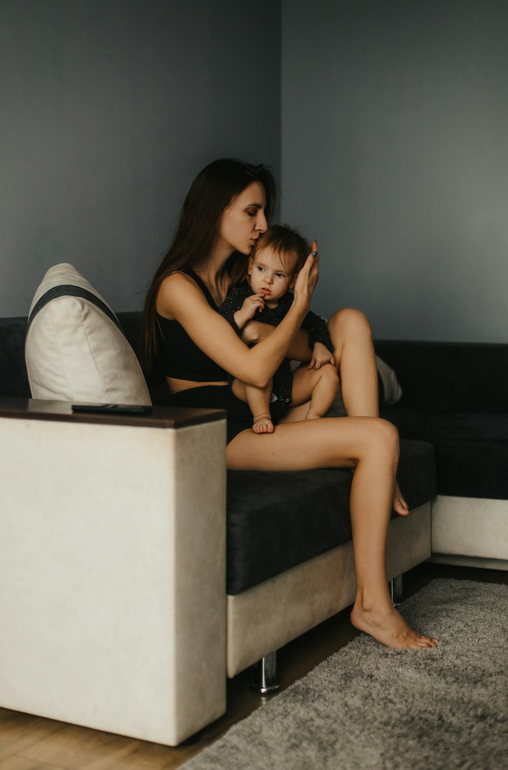 a woman sitting on a couch with a baby