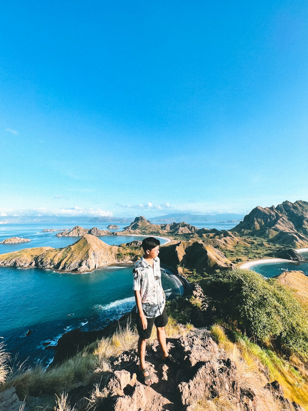 a person standing on a cliff above a body of water