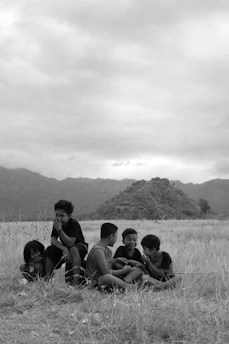 Children engaged in a fun leadership activity outdoors with mountains in the background.