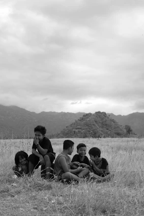 A group of joyful children playing together under a bright blue sky.