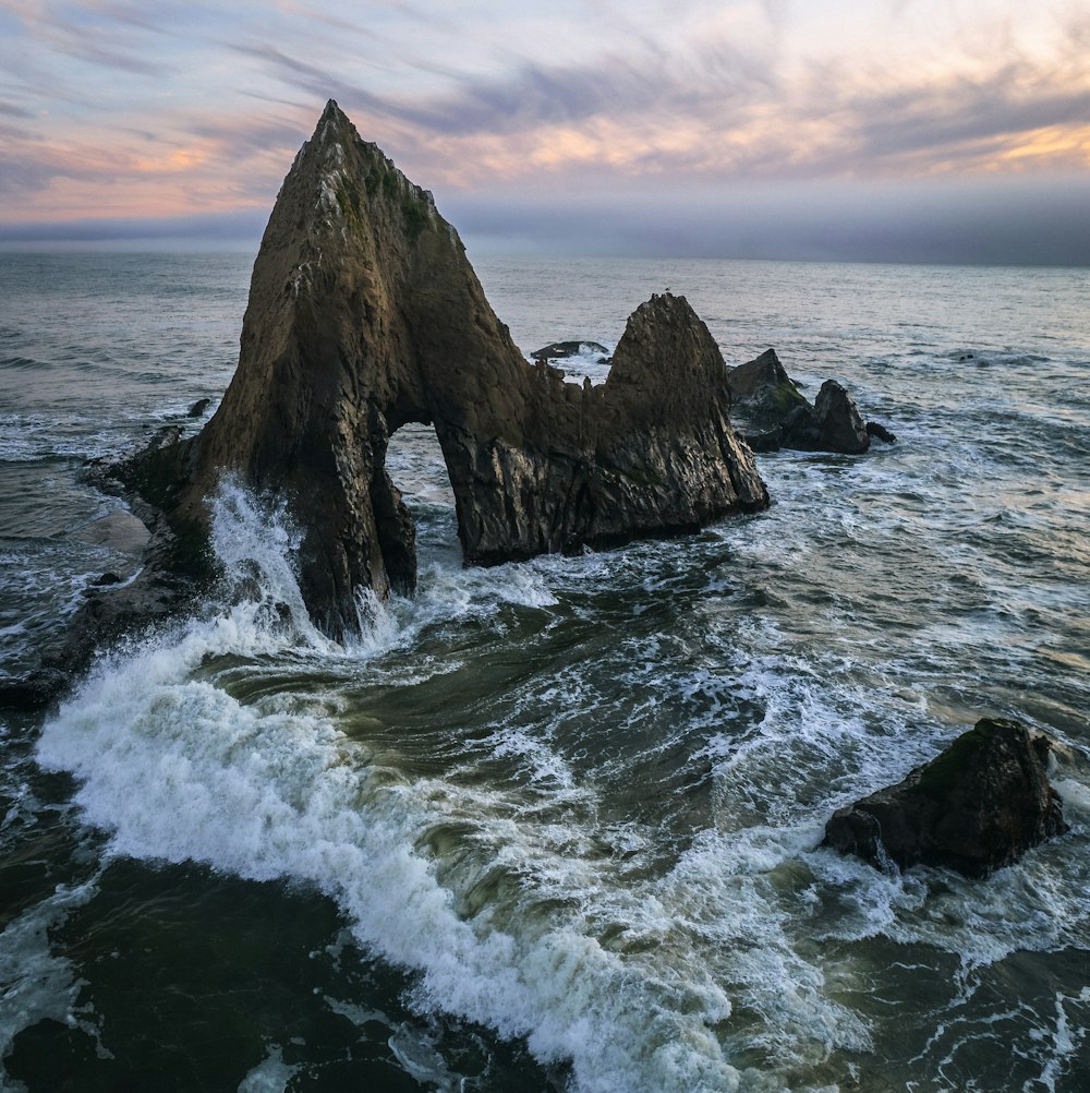 a rocky shoreline with waves crashing against it