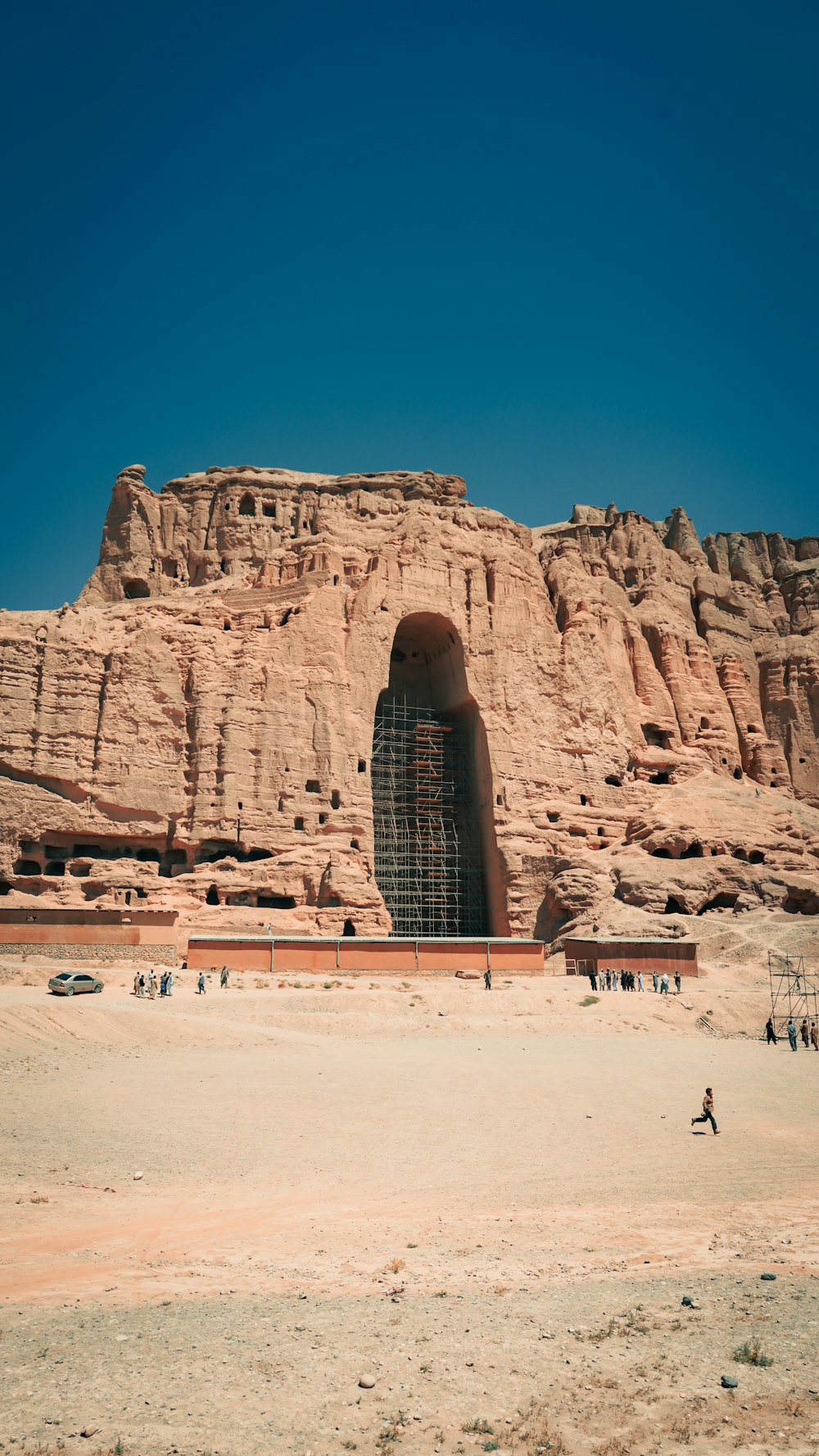 a large rock structure with people standing in front of it