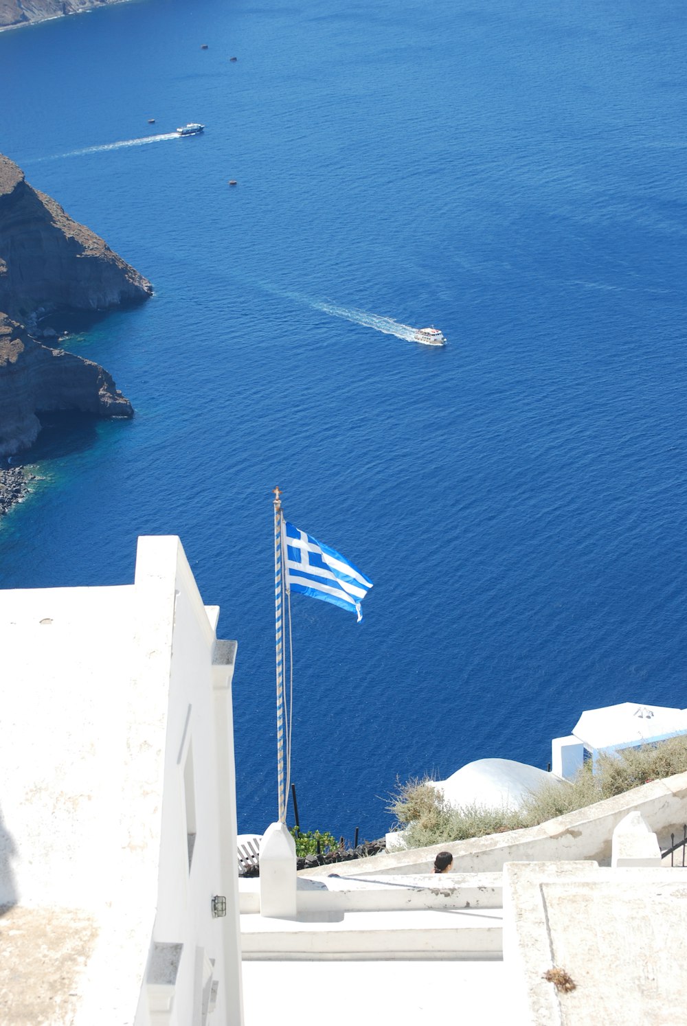 a flag on a pole by the water