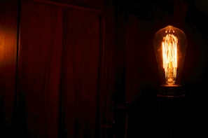 A sleek smart LED bulb glowing warmly in a modern living room