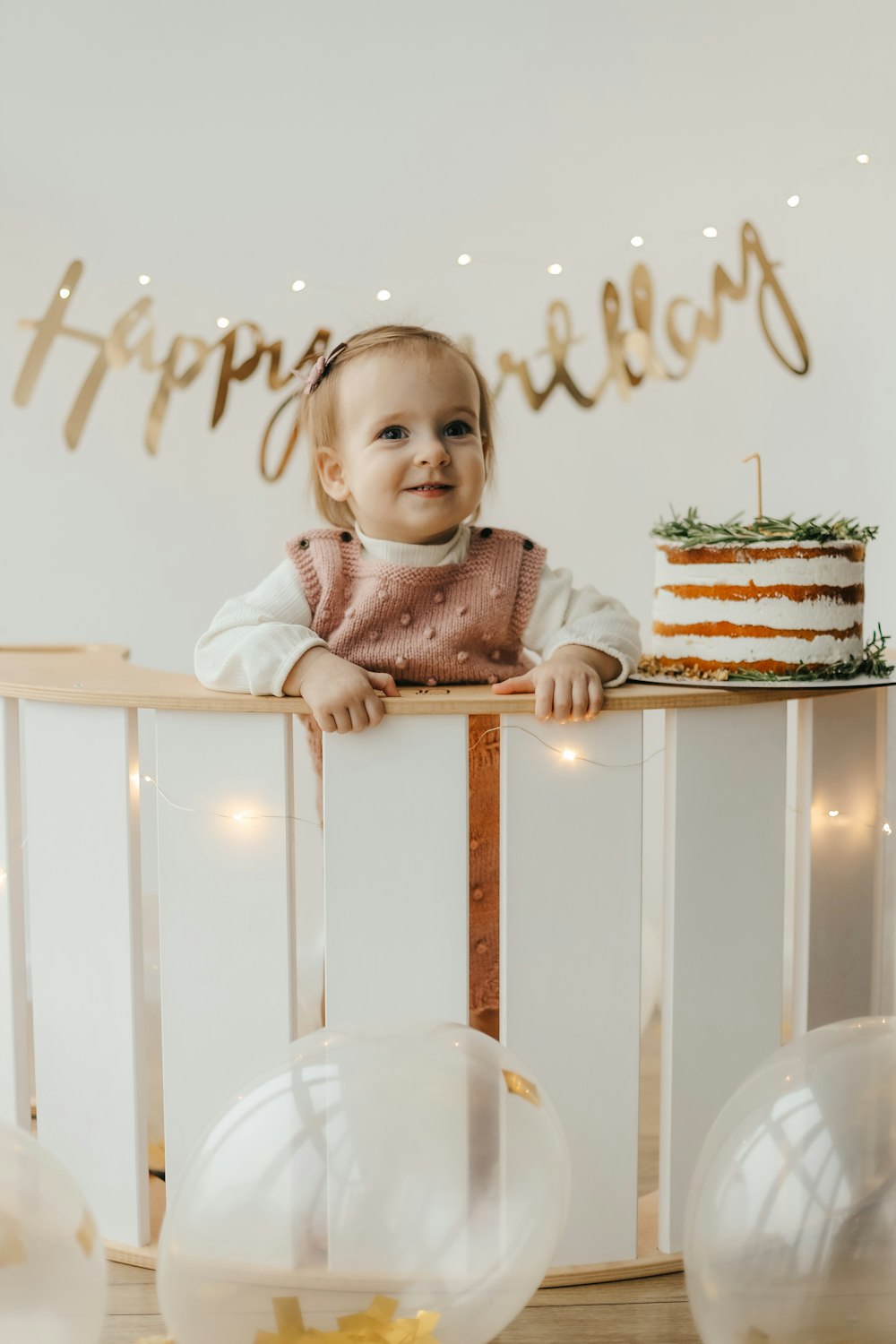 a girl sitting at a table with a cake and a glass of water