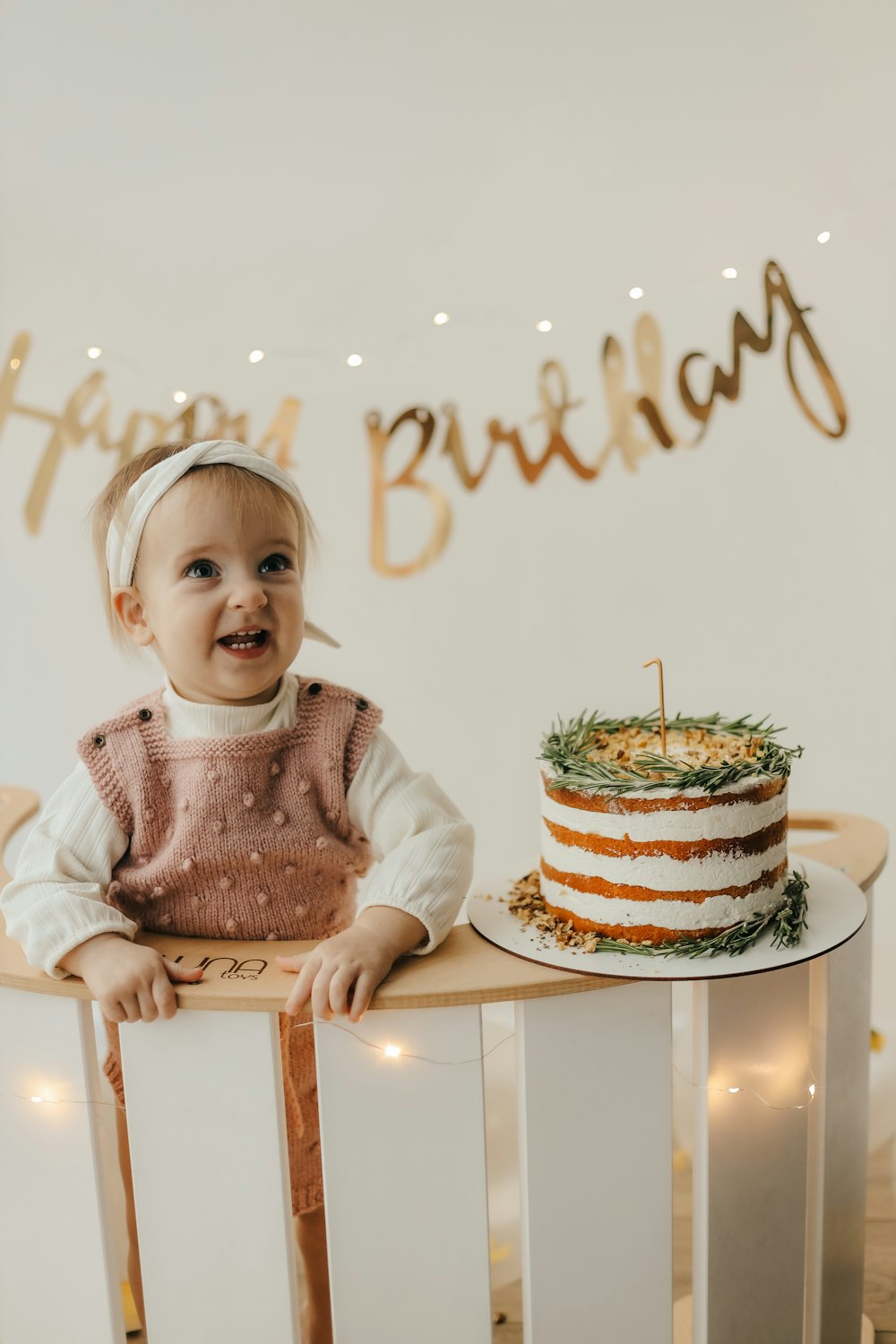 a baby sitting at a table with a cake on it