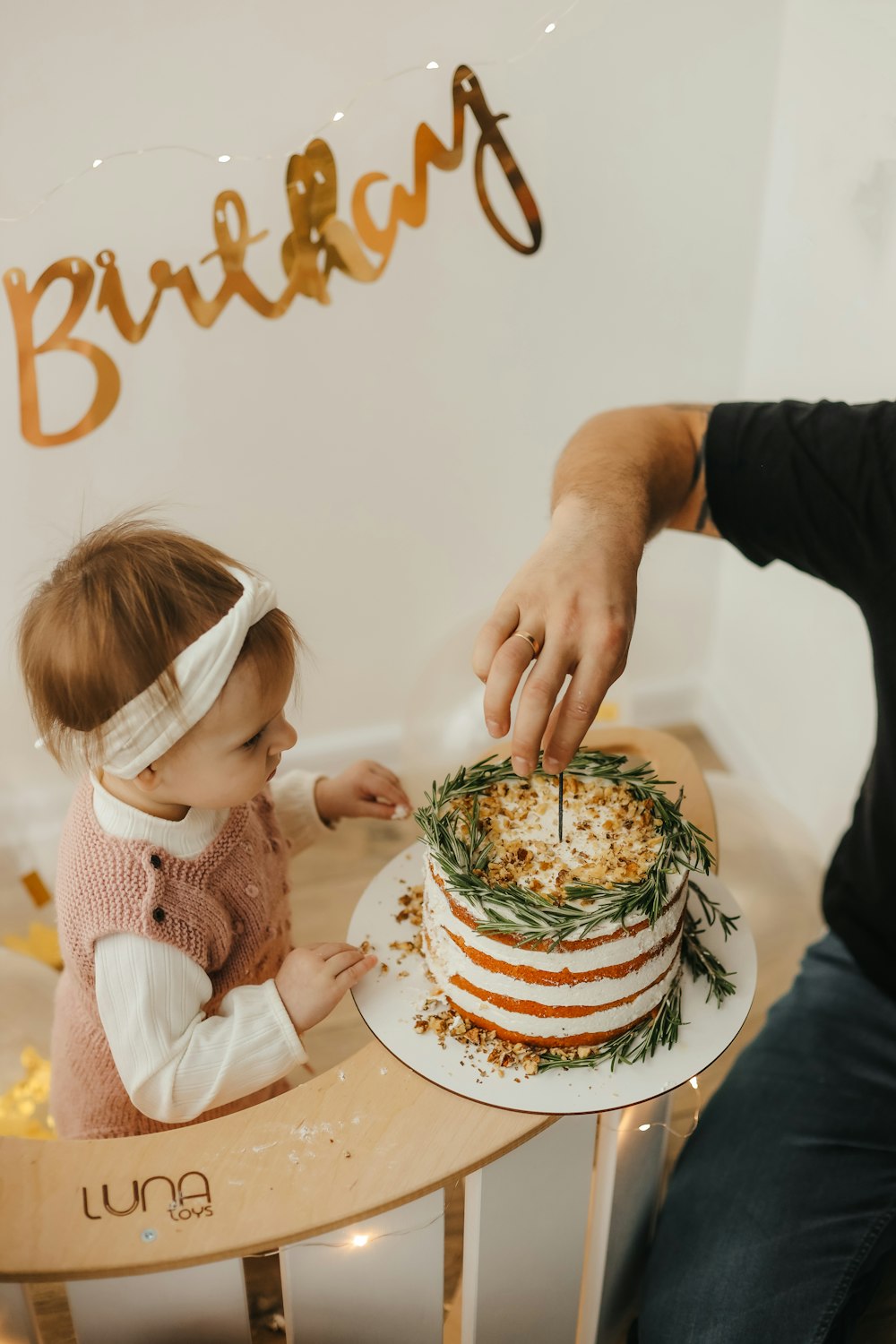 a person and a child cutting a cake