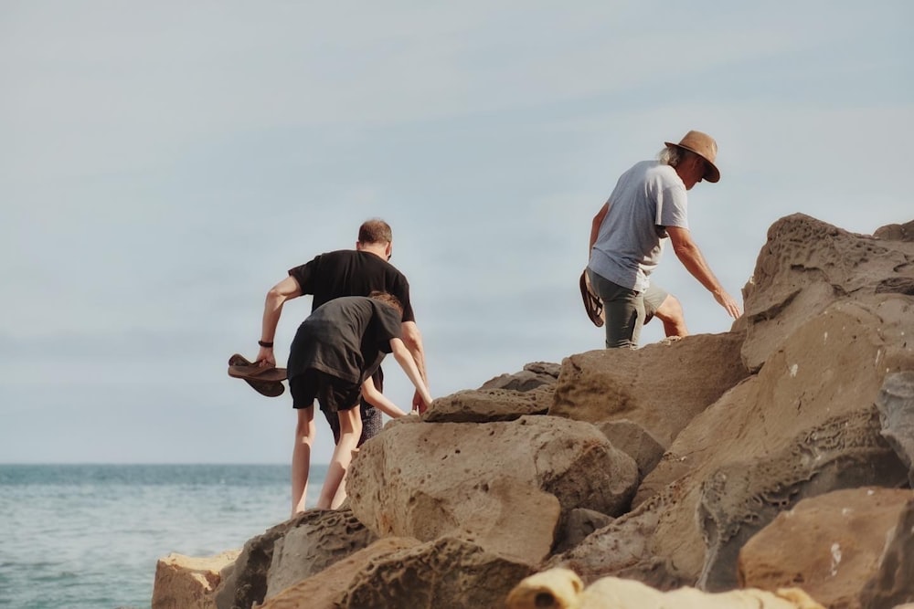 a man and a boy climbing a rocky cliff