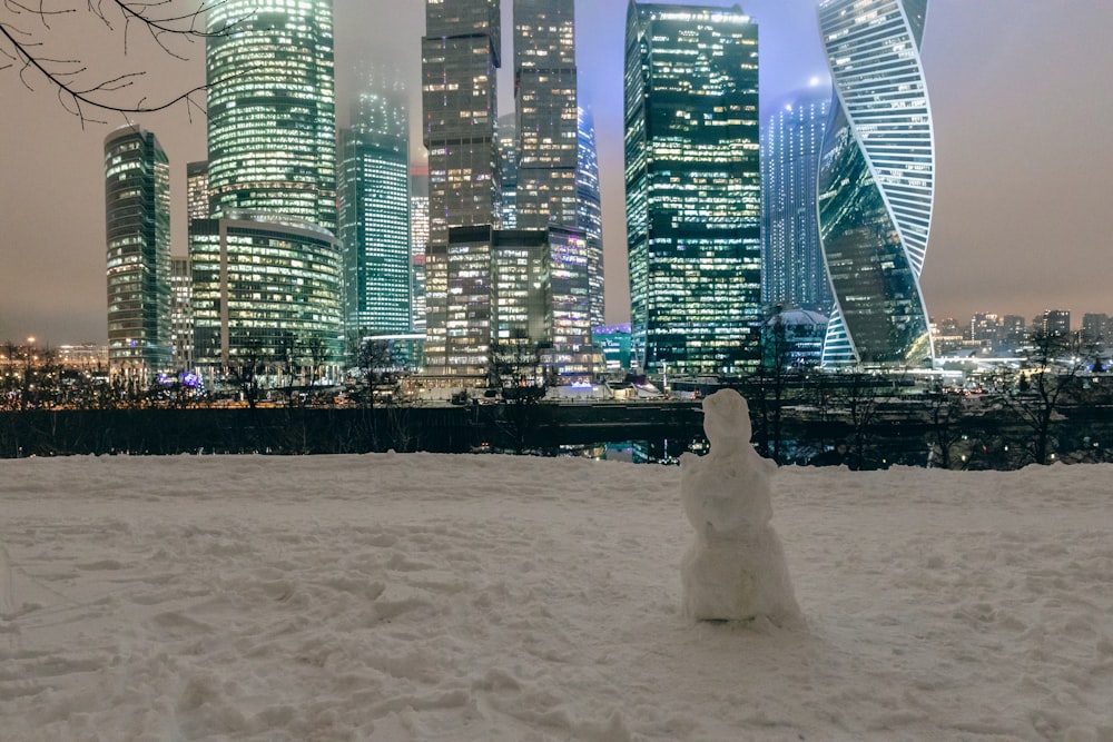 a snowman in front of a city skyline