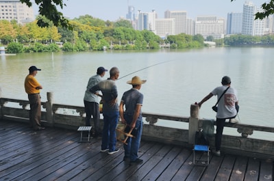 A small group of suburban anglers chatting and fishing by a stocked lake.