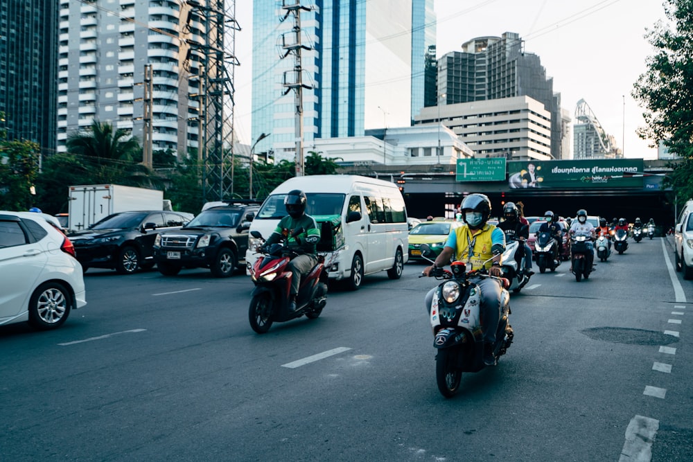 a group of people ride motorcycles down a street