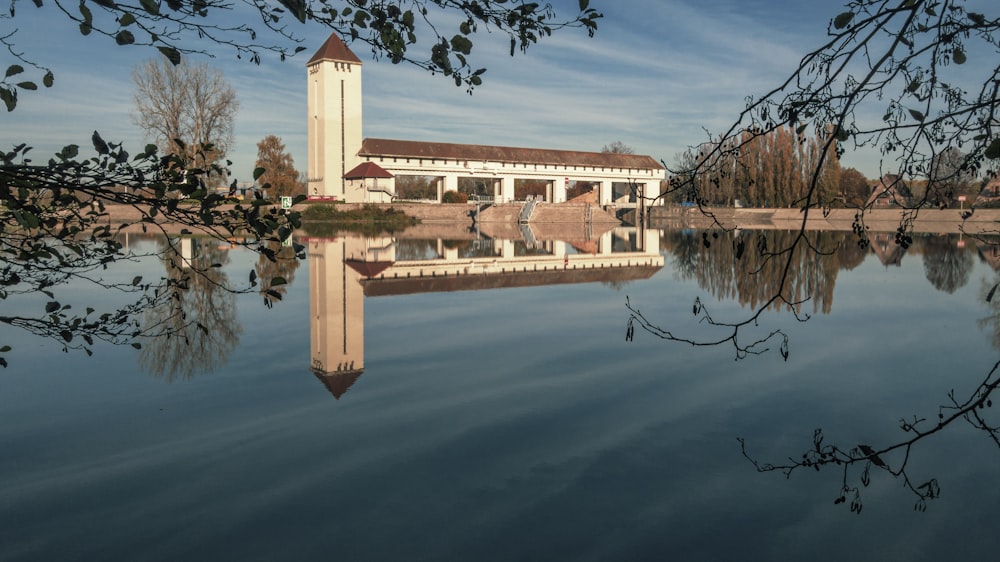 a building with a tower by a body of water