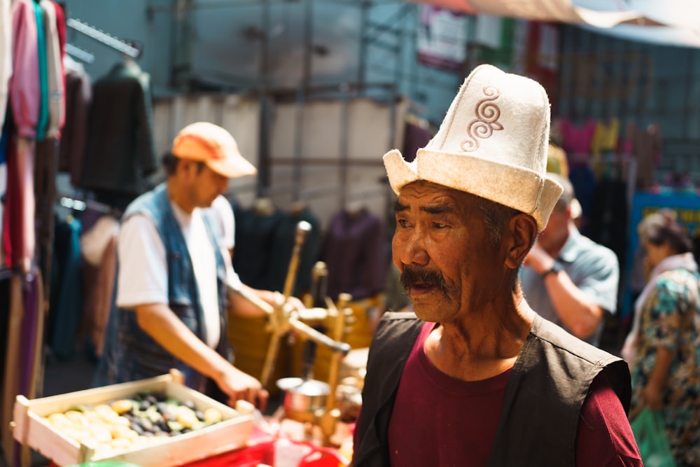 Eine Person mit Hut steht auf einem Markt