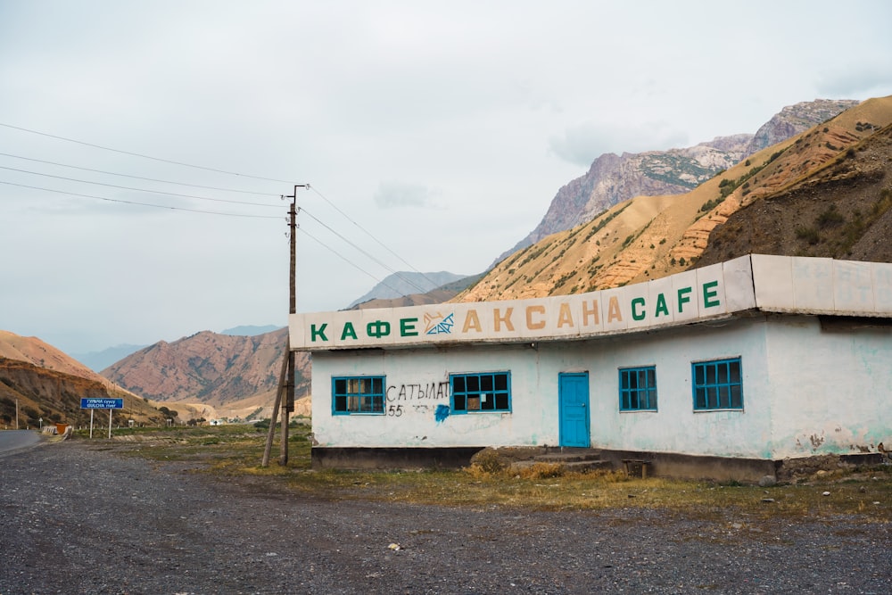 a white building with blue doors and mountains in the background