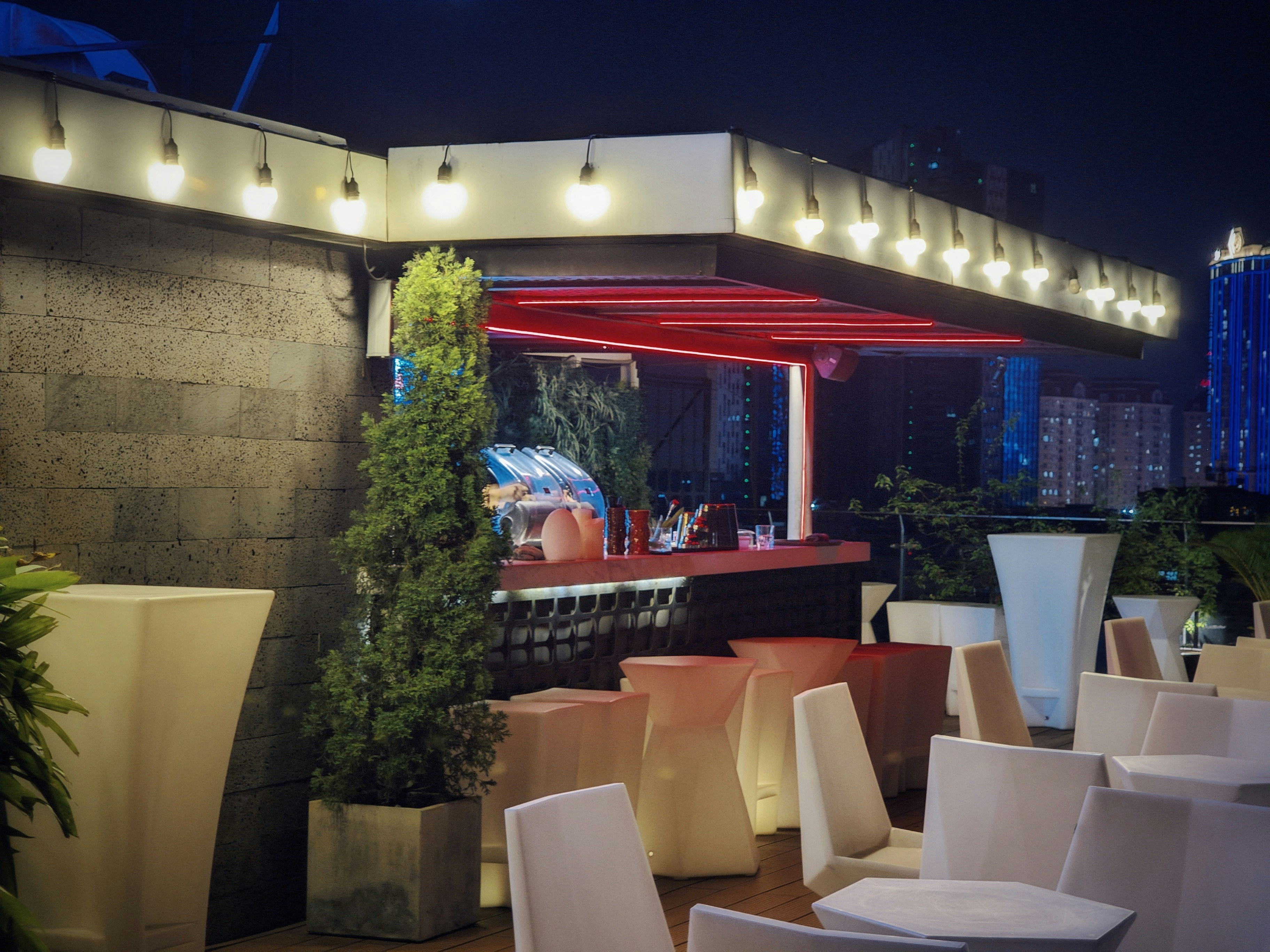 Rooftop bar at night with dramatic lighting and city views, Athens