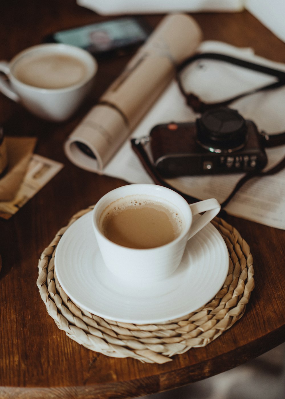 a cup of coffee and a camera on a table