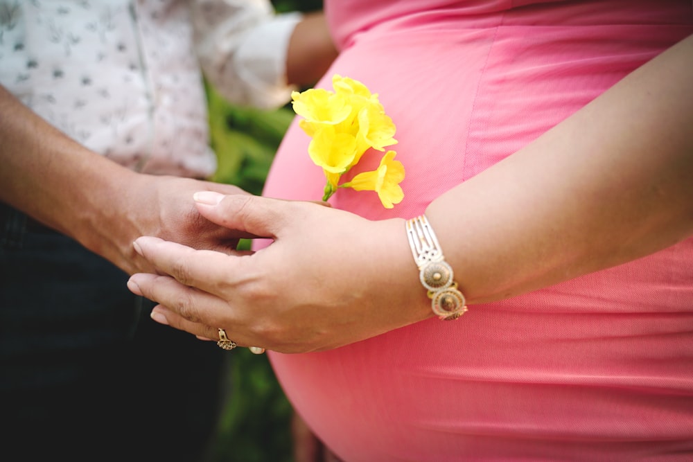 a woman holding a yellow flower