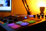 Close-up of mixing console with colorful sound levels lit up in a cozy studio.