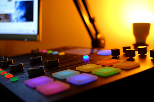 A close-up of a mixing console with colorful lights glowing during a worship session.