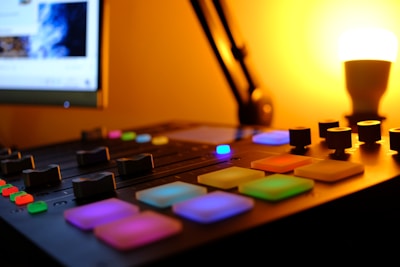 A vibrant mixing console lit up with colorful LEDs during a late-night recording session.