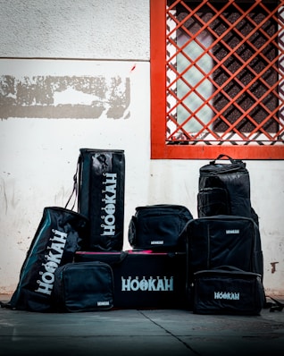 a group of luggage sits in front of a red and white wall