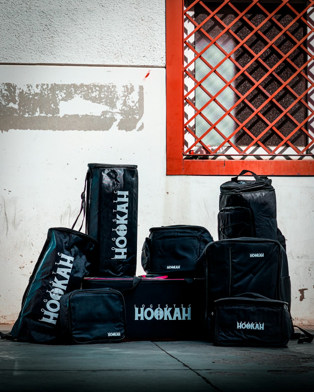 a group of luggage sits in front of a red and white wall