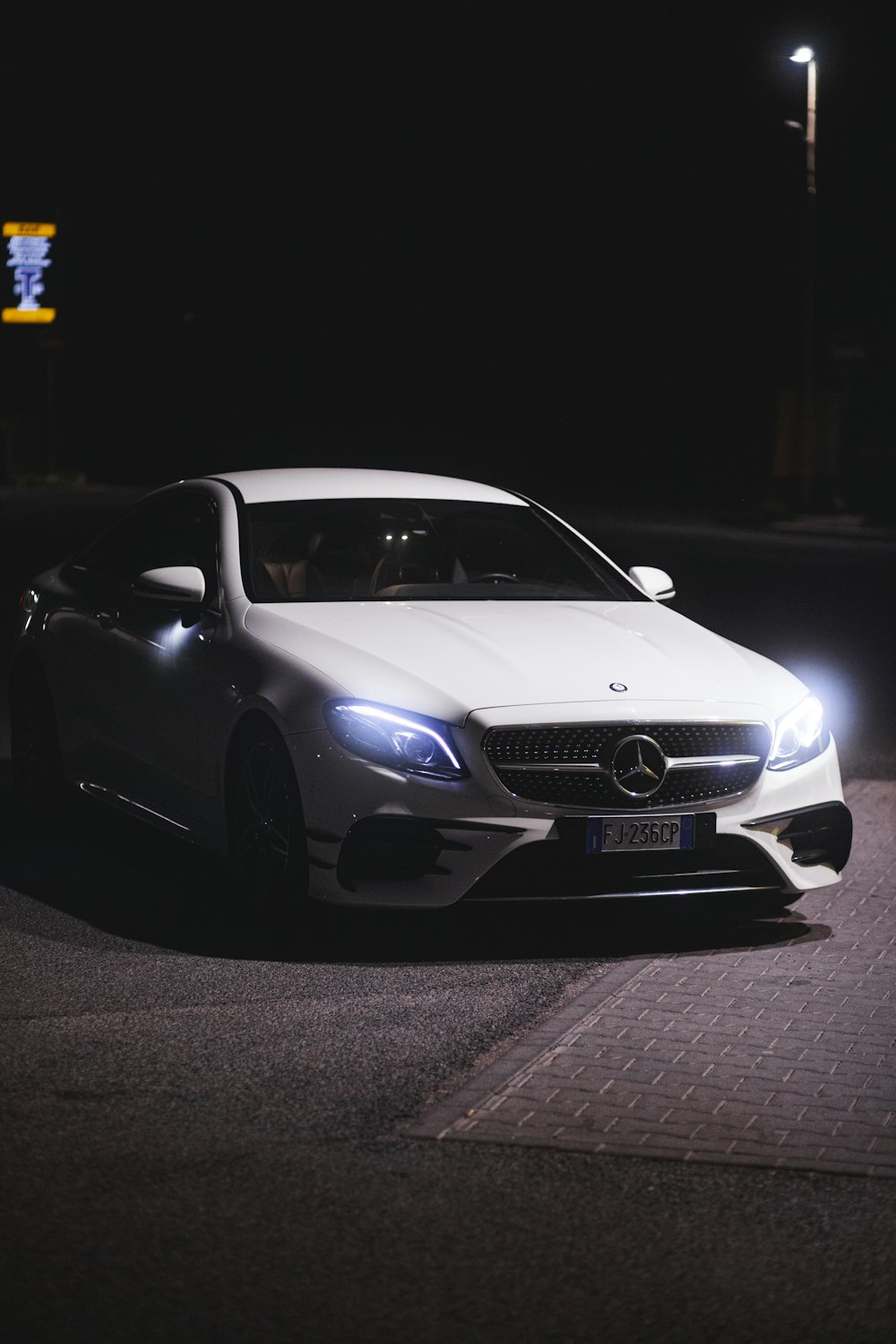 a white car parked on a street at night