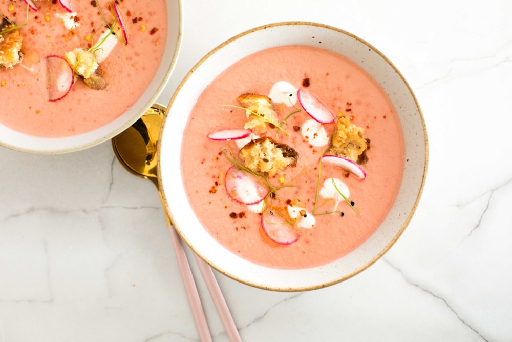 a bowl of soup with chopsticks