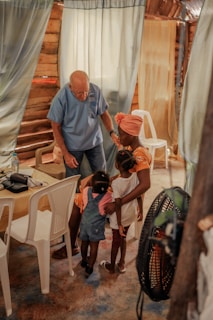 A lively workshop with children and elders sharing poems and songs in a rural community hall.