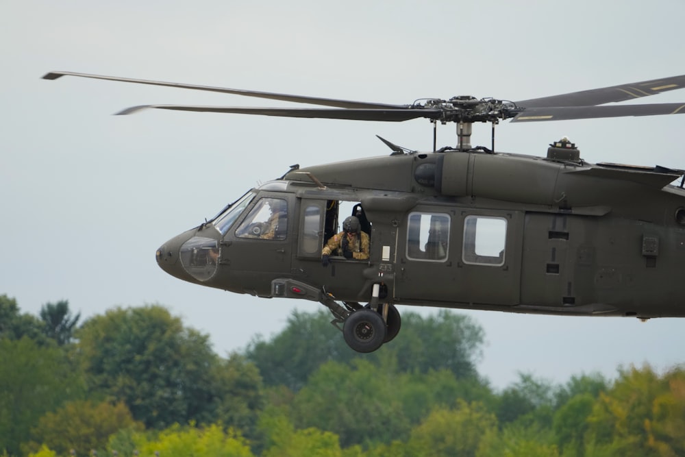 a helicopter flying over trees