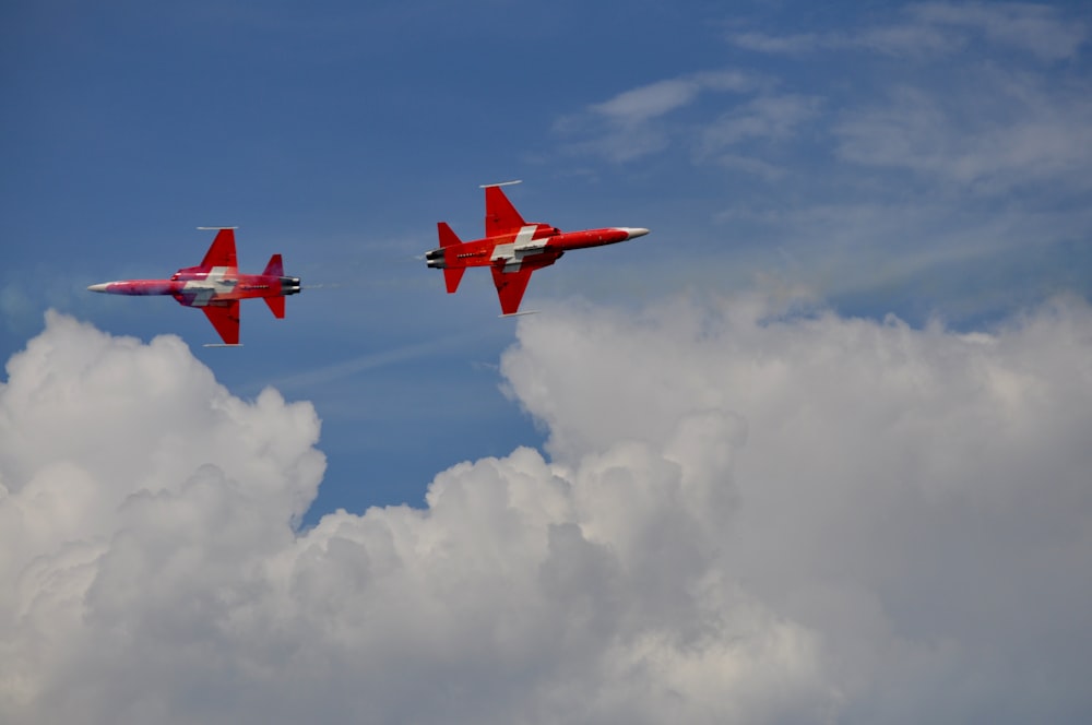 two red airplanes flying in the sky