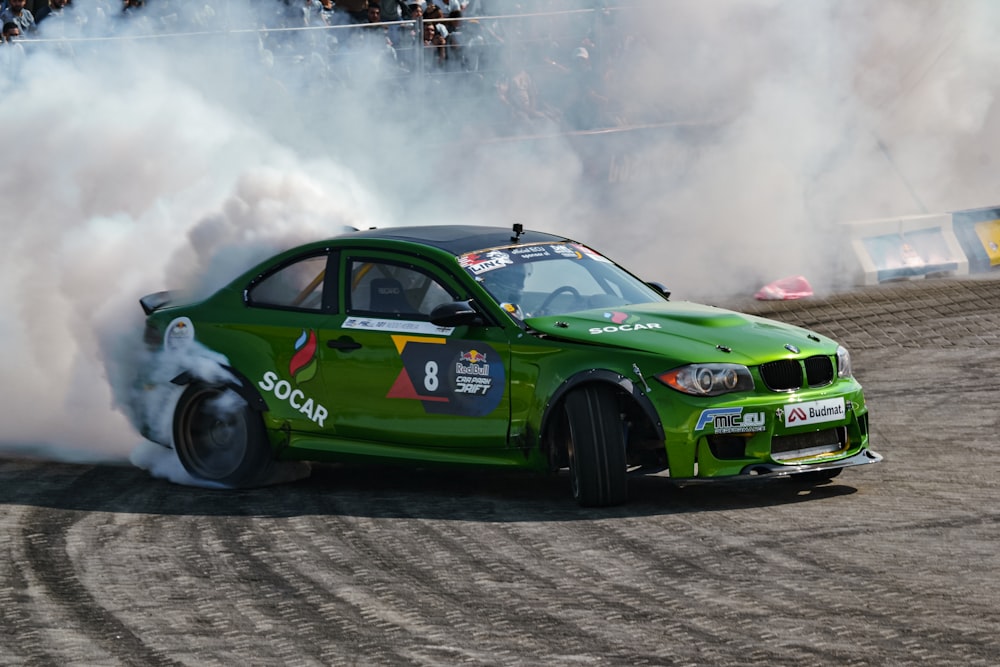 a green race car with smoke coming out of it