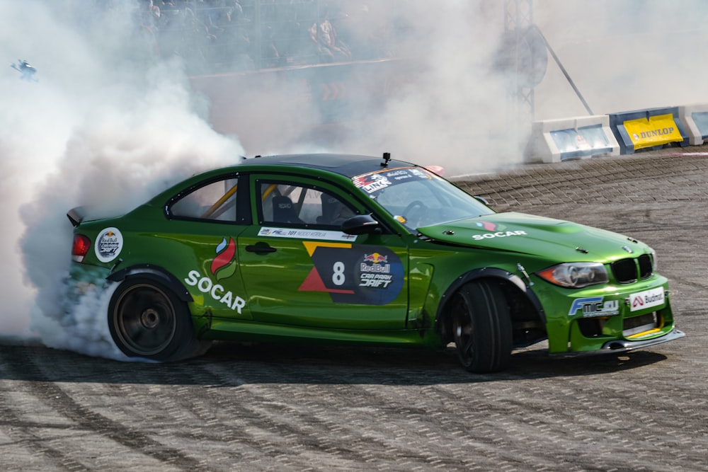 a green race car with smoke coming out of it