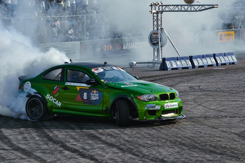 a green race car on a track