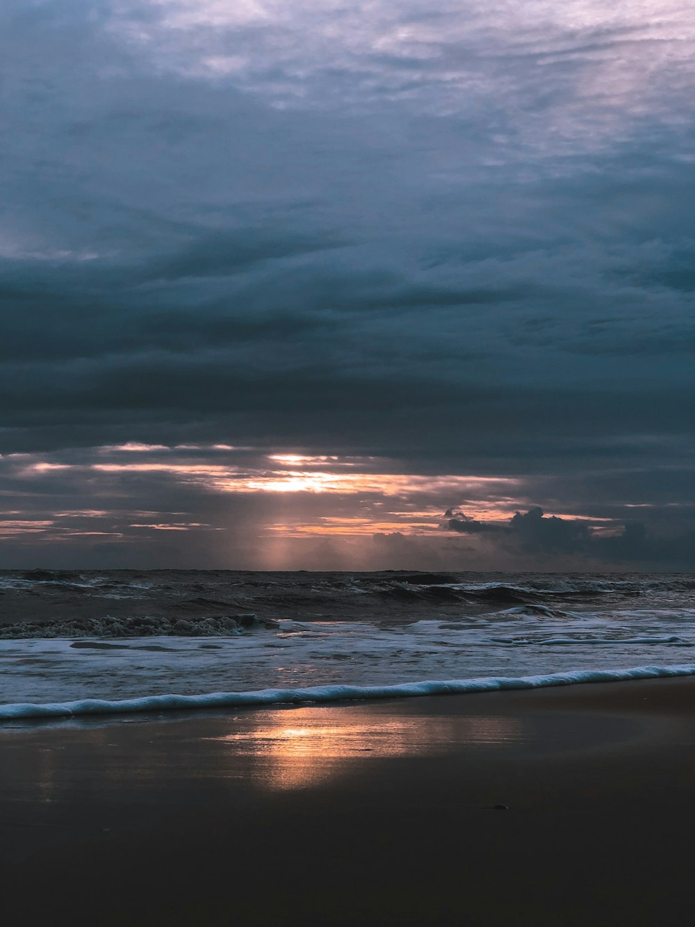 a beach with waves and a sunset