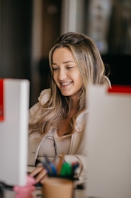 a woman smiling and writing on a piece of paper