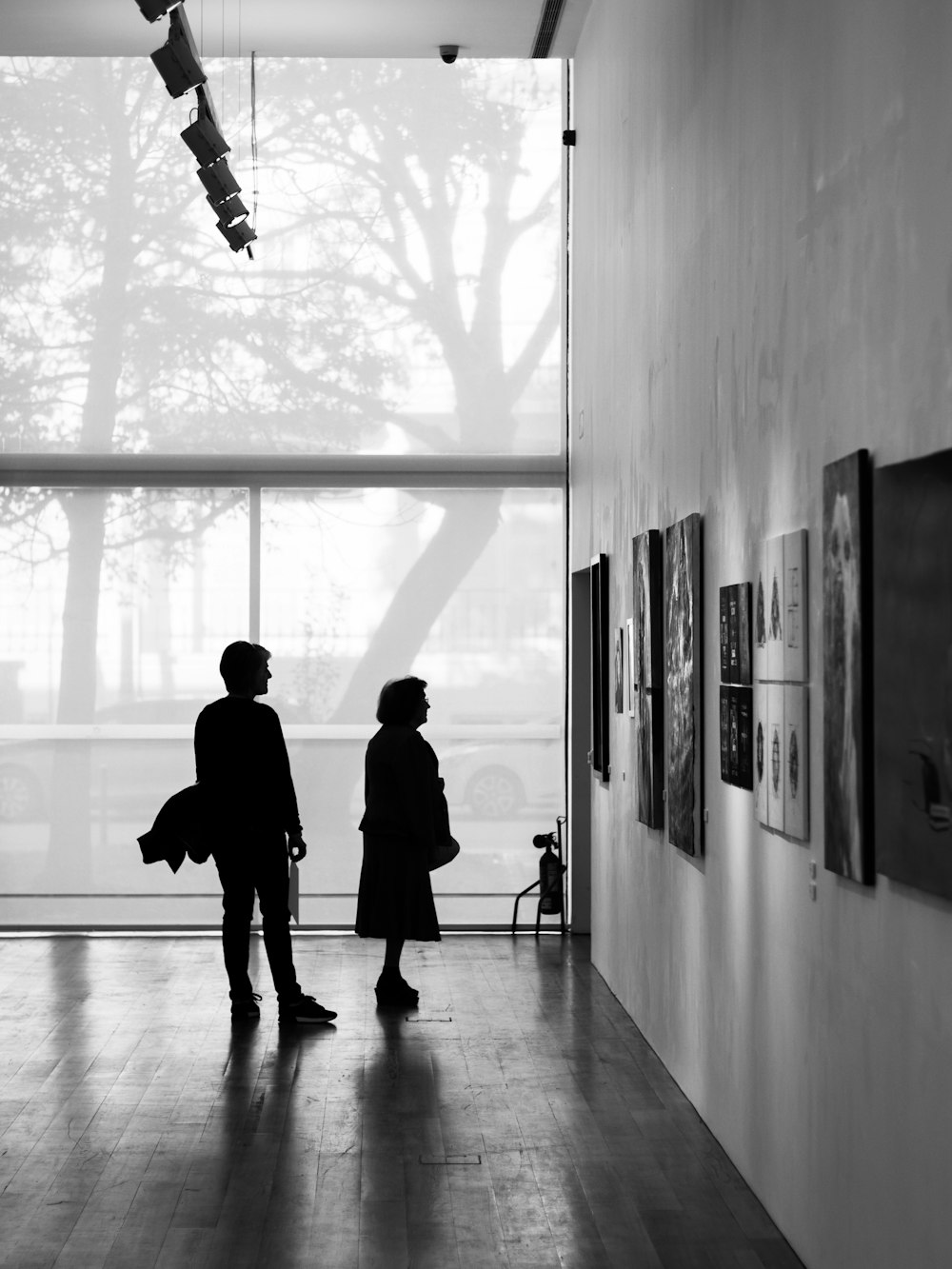 a man and a woman looking at art on the wall